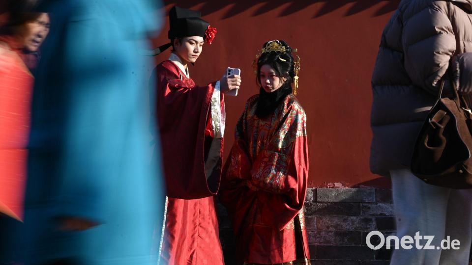 In traditioneller Kleidung vor dem Trommelturm in Peking. Chinesische Bräuche sind im Netz aktuell angesagt. Bild: Johannes Neudecker/dpa
