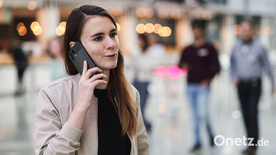 Die für KI zuständige Telekom-Mitarbeiterin Lena Drubel führt bei einer Testvorführung des KI-Assistenten ein Handytelefonat. Bild: Oliver Berg/dpa