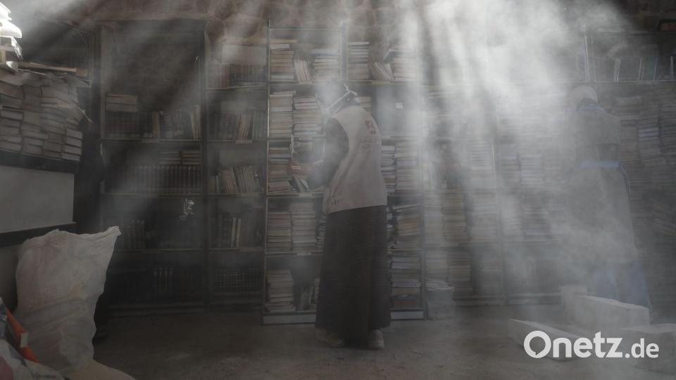 Palästinensische Freiwillige entstauben in der Bibliothek der Großen Omari-Moschee in der Altstadt von Gaza-Stadt Bücher, um beschädigte Bestände nach der zweijährigen Bombardierung des Gazastreifens zu retten und zu restaurieren. Bild: Omar Ashtawy/APA Images via ZUMA Press Wire/dpa