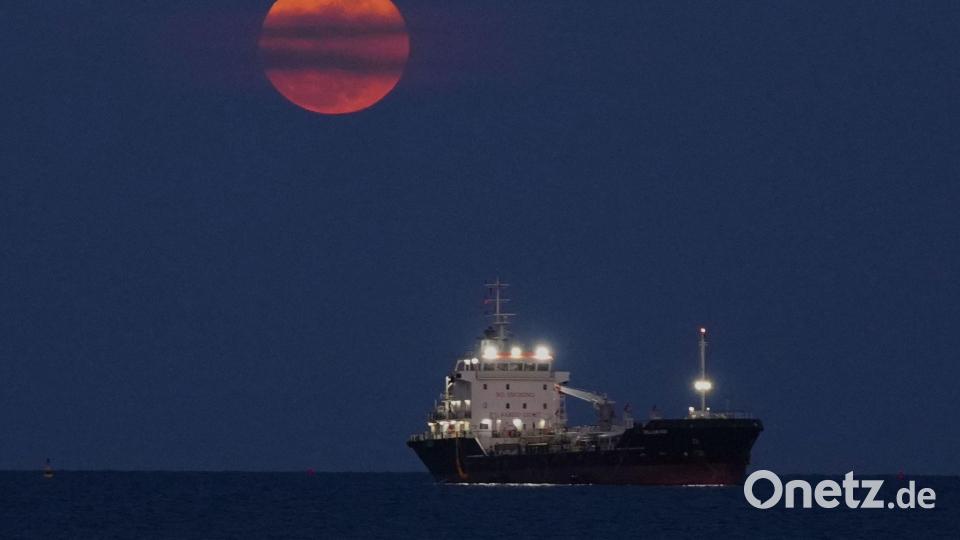 Ein Blutmond geht über dem Mittelmeer bei Limassol auf, wo ein Schiff vor Anker liegt. Bild: Petros Karadjias/AP/dpa