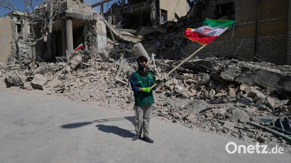 Iran-Krieg - Teheran: Ein Junge schwenkt eine iranische Flagge vor einer Polizeieinrichtung, die während der amerikanisch-israelischen Militäraktion getroffen wurde. Bild: Vahid Salemi/AP/dpa