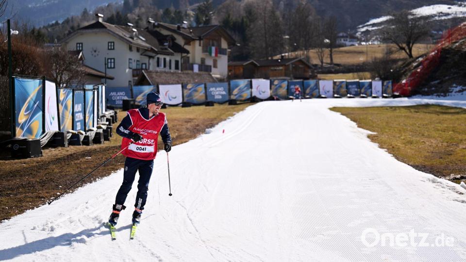 Ein weißer Streifen in viel grün: Frühlingshafte Temperaturen sorgen für schwere Bedingungen im Langlaufstadion. Bild: Martin Schutt/dpa