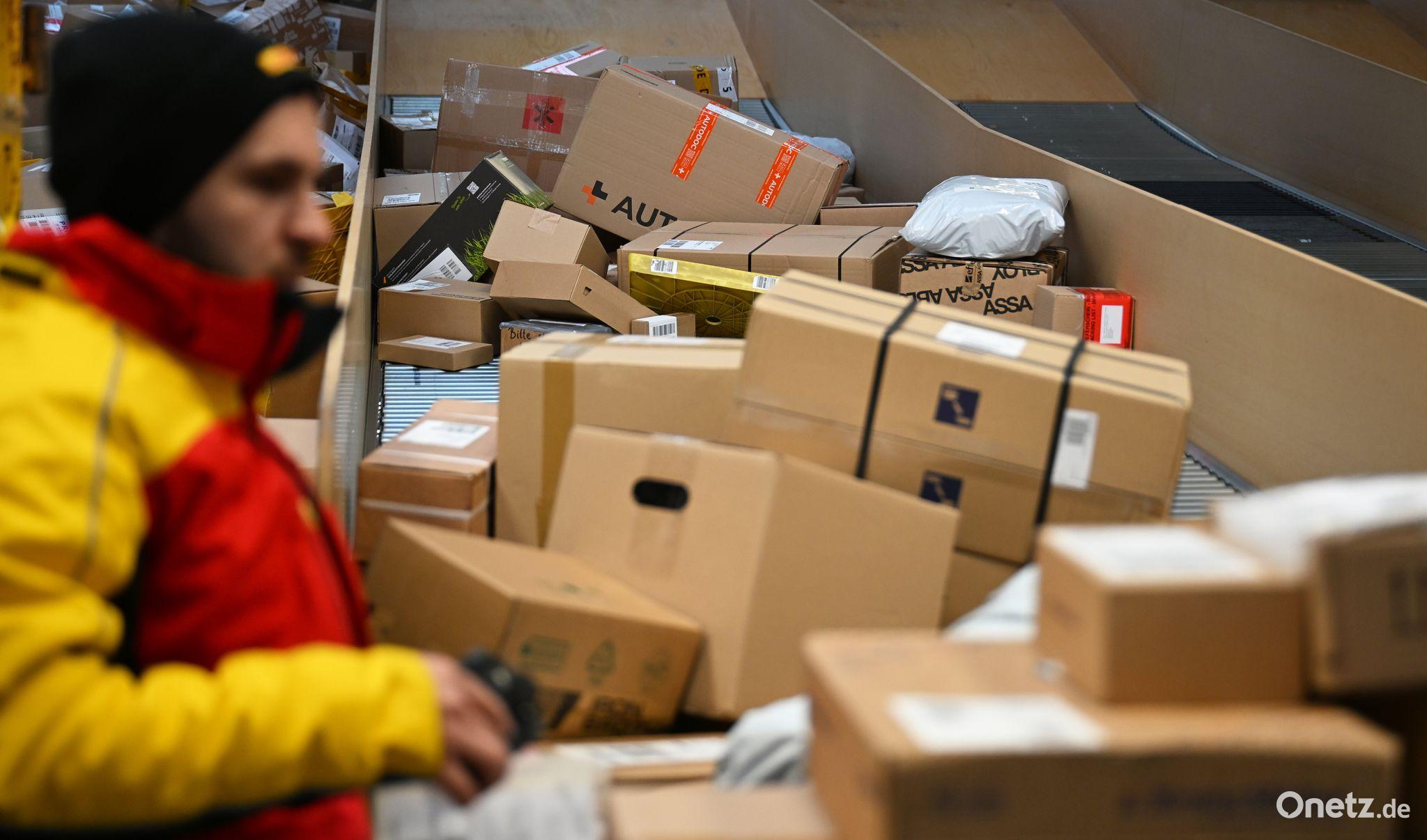 Ein DHL-Paketbote ist in einer Zustellbasis mit einer Vielzahl an Paketen beschäftigt. Der Logistikkonzern hat Jahreszahlen für 2025 vorgelegt, er hat profitablere Geschäfte gemacht als zuvor. Bild: Wolf von Dewitz/dpa