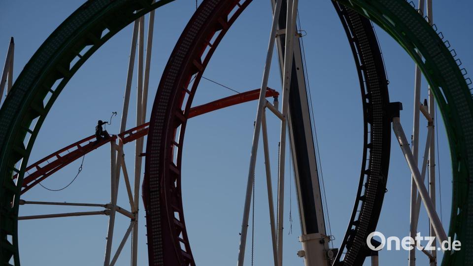 Eine Höhenkletterin nimmt bei den Aufbauarbeiten eine Schiene der Achterbahn auf dem Heiligengeistfeld in Hamburg entgegen. Der Aufbau für den Frühlingsdom hat begonnen. Bild: Marcus Brandt/dpa