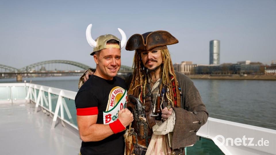 „Johnny Däpp“-Sänger und Johnny-Depp-Double schippern über den Rhein. Bild: Thomas Banneyer/dpa