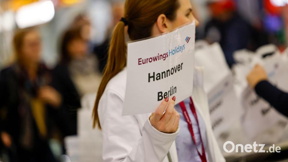 Eine Mitarbeiterin der Fluggesellschaft Eurowings hält ein Schild. Bild: Thomas Banneyer/dpa