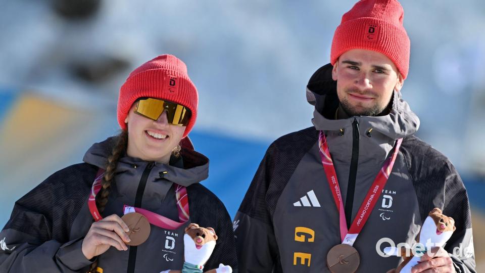 Leonie Walter und Guide bei der Siegerehrung mit dicker Mütze und Jacke. Bild: Martin Schutt/dpa