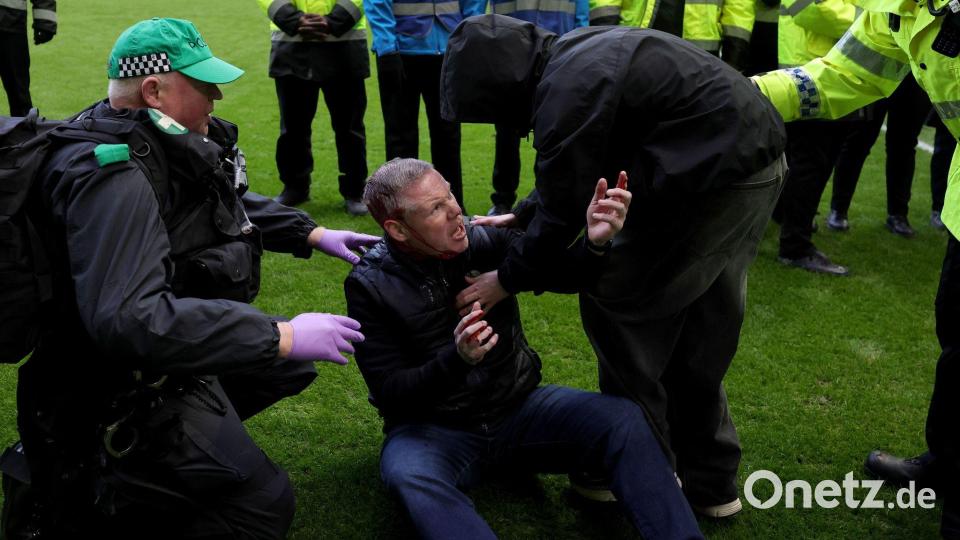 Die Polizei schritt ein, nachdem Celtic- und Rangers-Fans auf das Spielfeld liefen. Bild: Steve Welsh/PA/AP/dpa