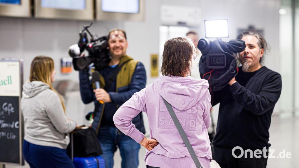 Dubai-Touristen geben nach ihrer Landung Kameramännern Interviews. Bild: Moritz Frankenberg/dpa