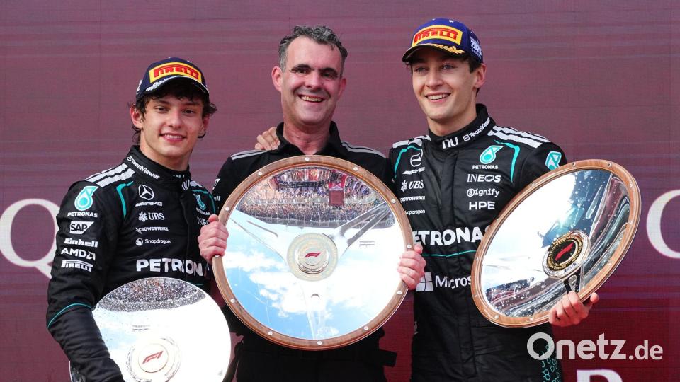 George Russell (r) freut sich über Silbergeschirr. Bild: Scott Barbour/AP/dpa