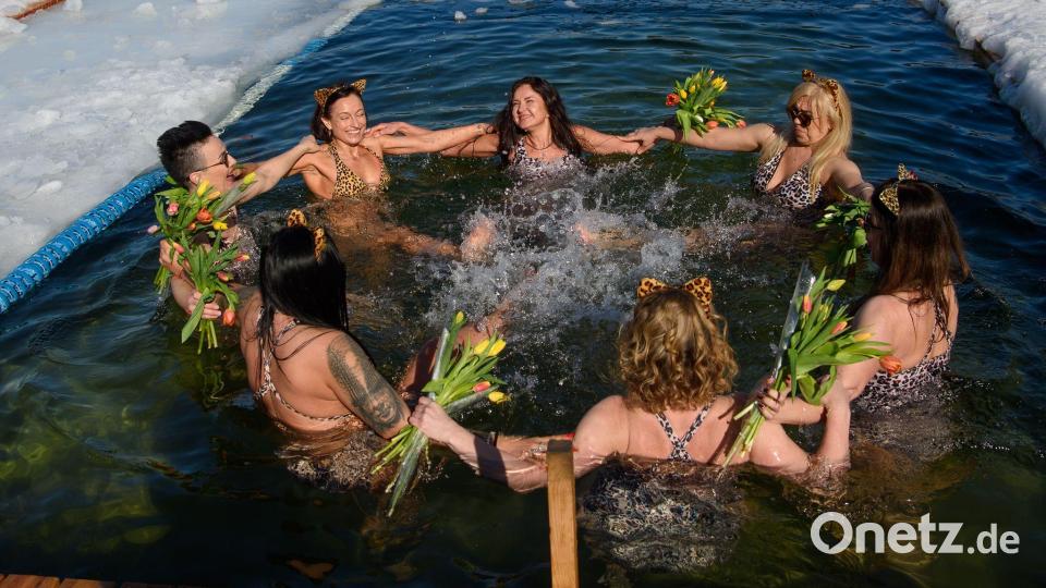 Mitglieder eines Winterschwimmclubs feiern in einem Eisloch den Internationalen Frauentag. Bild: Yauhen Yerchak/SOPA Images via ZUMA Press Wire/dpa