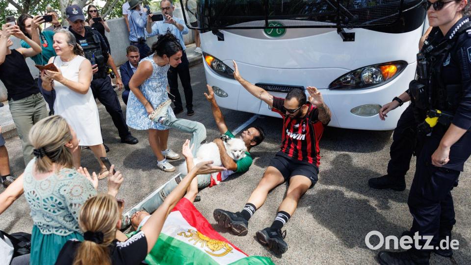 Demonstranten protestierten, während der Bus mit iranischen Spielerinnen und Mitarbeitern abfuhr. Bild: Russell Freeman/AAP/dpa