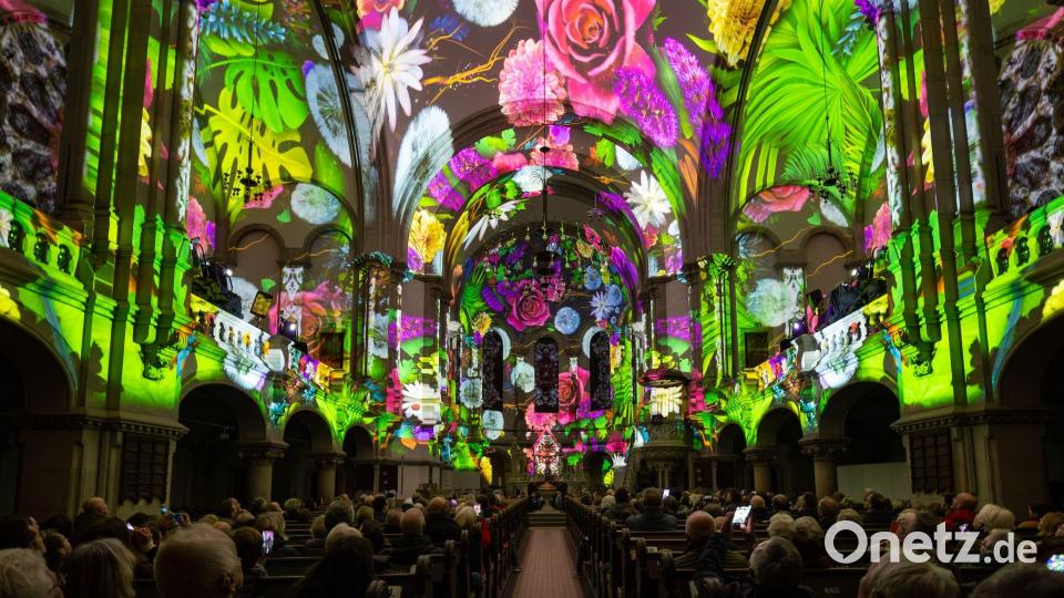 Menschen verfolgen in der Dresdner Martin-Luther-Kirche eine Lichtshow. Bild: Jürgen Lösel/dpa/ZB