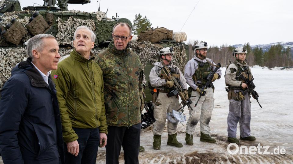 Mark Carney (l-r), Premierminister von Kanada, Jonas Gahr Støre, Ministerpräsident von Norwegen, und Bundeskanzler Friedrich Merz (CDU) stehen auf dem Truppenübungsplatz während der Nato-Übung «Cold Response» neben Soldaten vor einem Panzer. (zu dpa: «Merz' eisige Botschaft aus der Arktis an Trump») Bild: Soeren Stache