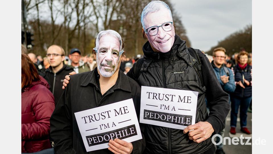 Zwei Personen nehmen an der Demonstration „Transparenz, Rechtsstaat und Schutz von Minderjährigen” mit einer Maske von Jeffrey Epstein (l) und Bill Gates mit einem Schild mit der Aufschrift „Trust me I‘m a pedophile“ teil. Bild: Fabian Sommer/dpa
