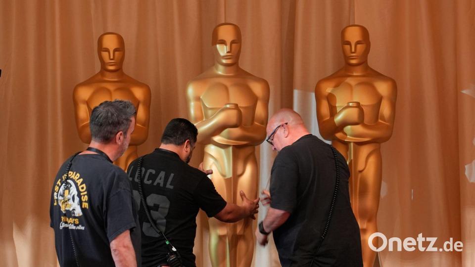 Arbeiter bewegen Oscar-Statuen entlang des roten Teppichs vor der Oscar-Verleihung in Los Angeles. Bild: John Locher/AP/dpa