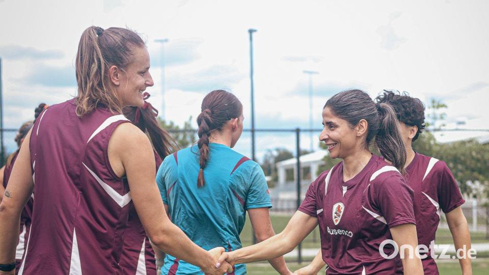 Atefeh Ramezanisadeh (r) wird von einer Mitspielerin begrüßt. Bild: Brisbane Roar/Brisbane Roar/AP/dpa