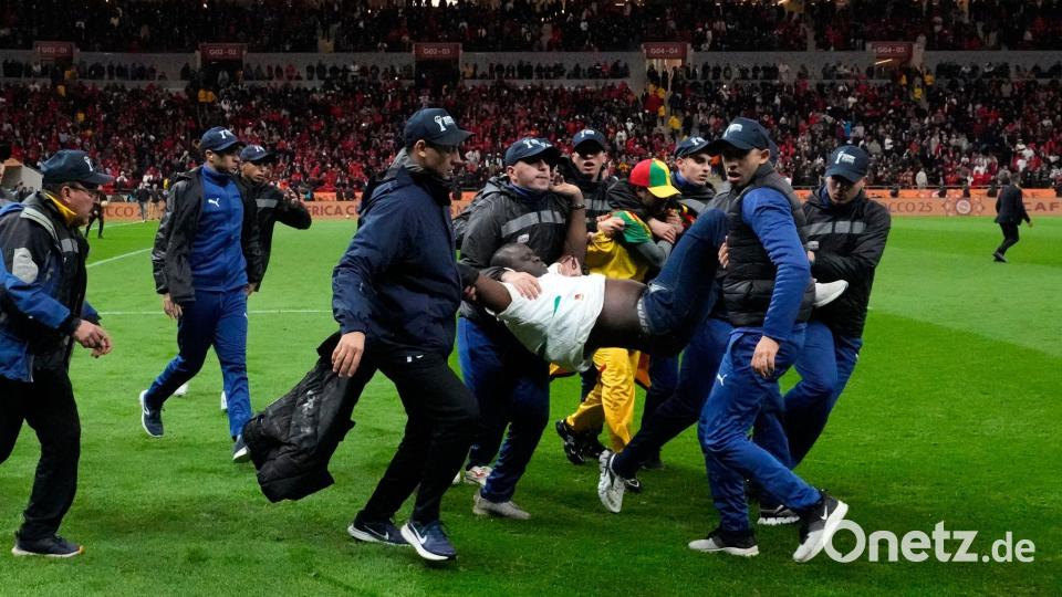 Ein auf den Platz gestürmter Anhänger des Senegals wurde von Sicherheitskräften weggetragen. (Archivbild) Bild: Themba Hadebe/AP/dpa