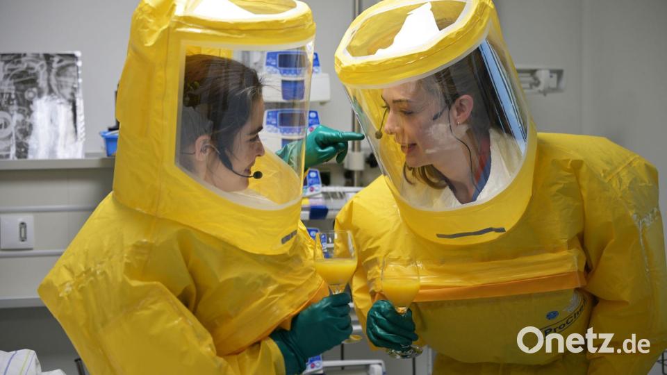 Die Helfer müssen sich per Sprechfunk verständigen - in den Anzügen hören sie sonst nichts. Bild: Malin Wunderlich/dpa