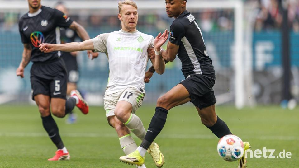 Werders Marco Grüll (l) wird von Wolfsburgs Jeanuel Belocian bedrängt. Bild: Andreas Gora/dpa