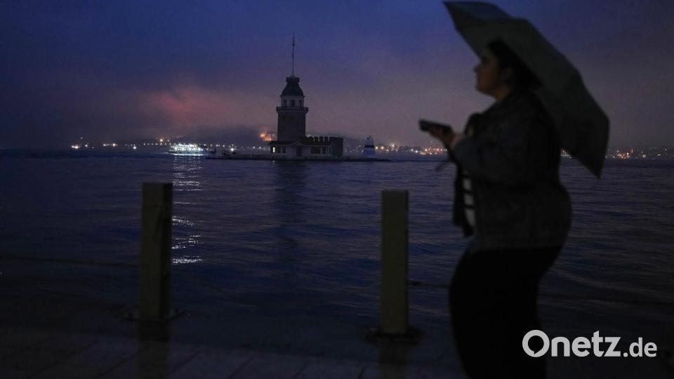 Eine Frau geht an einem regnerischen Tag in Istanbul am Jungfernturm am Bosporus vorbei. Bild: Francisco Seco/AP/dpa