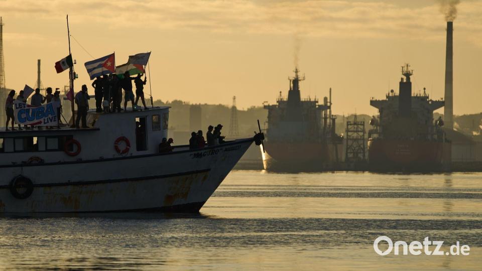 Aktivisten schwenken kubanische und palästinensische Fahnen auf dem Schiff „Maguro“, das im Rahmen des Konvois „Nuestra America“ (Unser Amerika) aus Mexiko mit humanitärer Hilfe eintrifft, in der Bucht von Havanna. Bild: Ramon Espinosa/AP/dpa