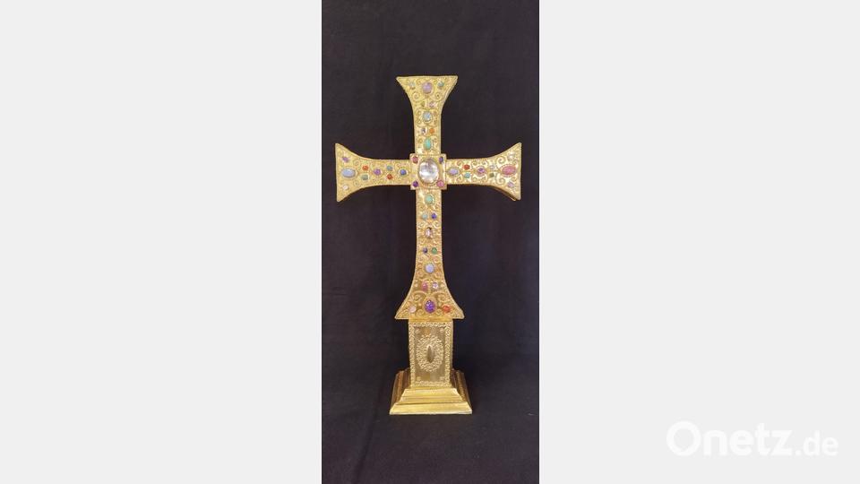 Das selbstgefertigte Kreuz mit Olivenholzkern und vergoldeten Kupferblechplatten. Die Verbindung der Platten ist mit selbst geflochtenen Drähten mit Druck und Zug verbunden. Zeitaufwand für die Metallarbeiten ca. 400 Stunden. In der Mitte ein Bergkristall mit Linseneffekt, dahinter ein winziger Holzsplitter vom Kreuz Jesu. Die gekauften Steine hat er geschliffen, Zeitaufwand ca. 150 Stunden. Bild: Monika Ziegeler