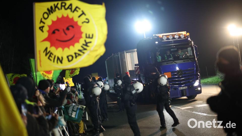 Ein Schwertransporter mit einem Castor-Behälter fährt an Teilnehmer einer Anti-Atomkraft-Demonstration vorbei. Bild: Christoph Reichwein/dpa