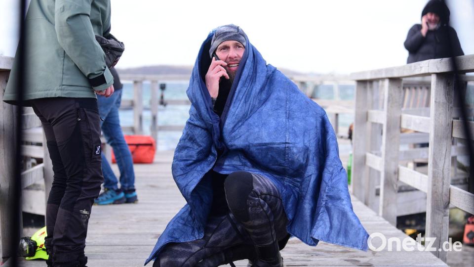 Robert Marc Lehmann geht auf Tuchfühlung mit einem gestrandeten Wal in der Ostsee. Bild: Daniel Bockwoldt/dpa