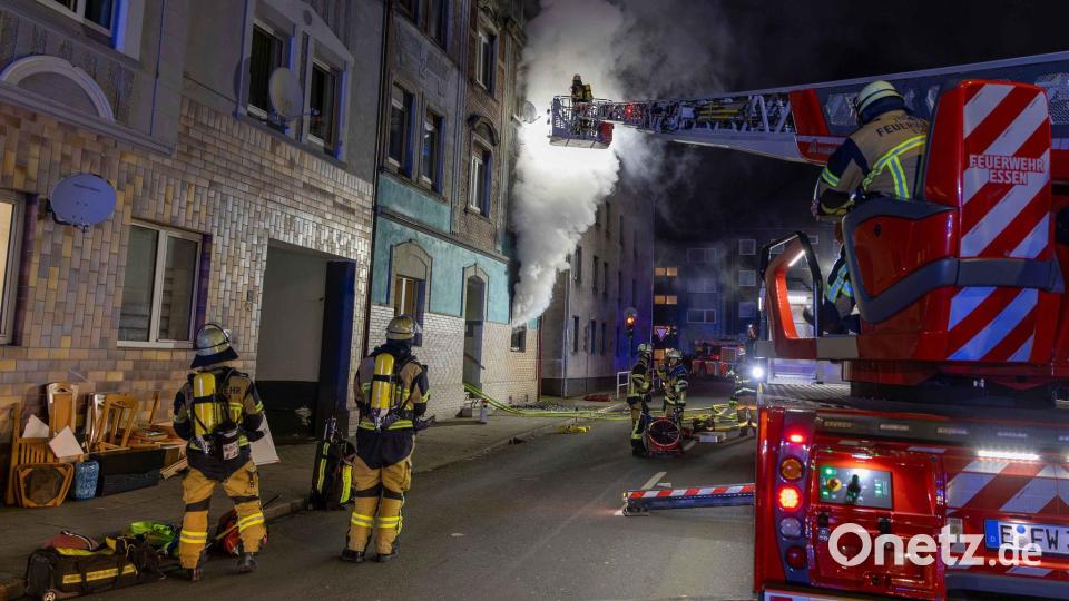 Feuerwehrleute sind u.a. mit einer Drehleiter damit beschäftigt, einen Brand in einem Wohnhaus in Essen zu bekämpfen. Bild: Justin Brosch/dpa