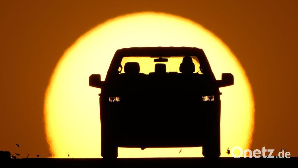 Ein Autofahrer wird von der untergehenden Sonne angestrahlt. Bild: Charlie Riedel/AP/dpa