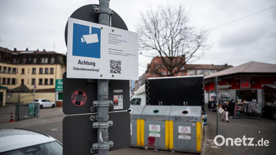 Schilder weisen auf die Videoüberwachung an den Glascontainern in der Nürnberger Südstadt hin. Dabei handelt es sich um ein Pilotprojekt. Bild: Daniel Vogl/dpa