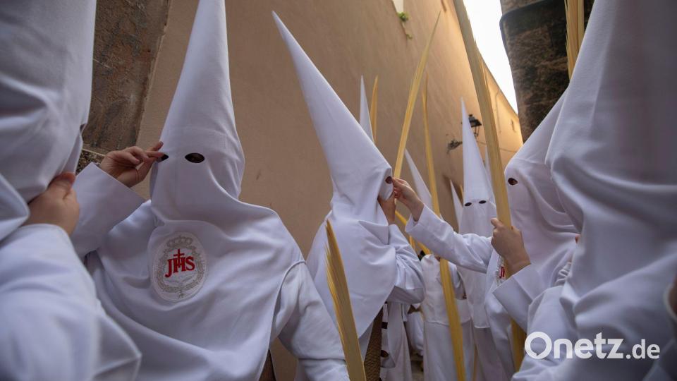 Büßer (Nazarenos) nehmen an einer Prozession am Palmsonntag (Domingo de Ramos) zum Auftakt der Karwoche in Spanien teil. Bild: Clara Margais/dpa