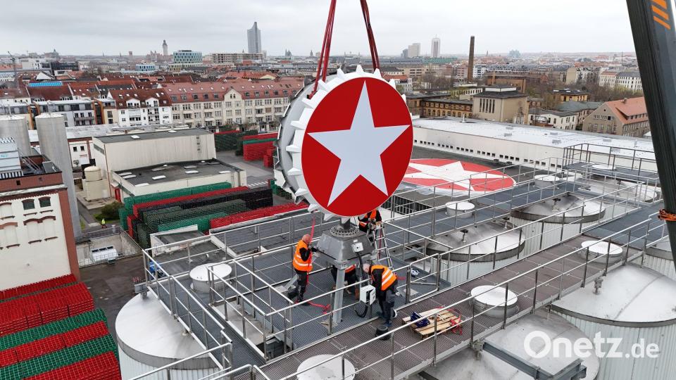 Leipzig: Der Sterni-Kronkorken ist wieder da – Kran hebt Kult-Leuchtreklame aufs Brauhaus Bild: Sebastian Willnow/dpa