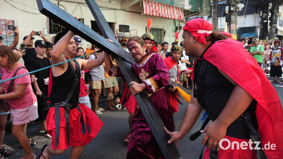 Ein Büßer mit einem Holzkreuz während eines Passionsspiels in Mandaluyong, das die Leiden Jesu Christi nachstellt. Die Szene spielt am Gründonnerstag im Rahmen der Karwochen-Feierlichkeiten. Bild: Aaron Favila/AP/dpa