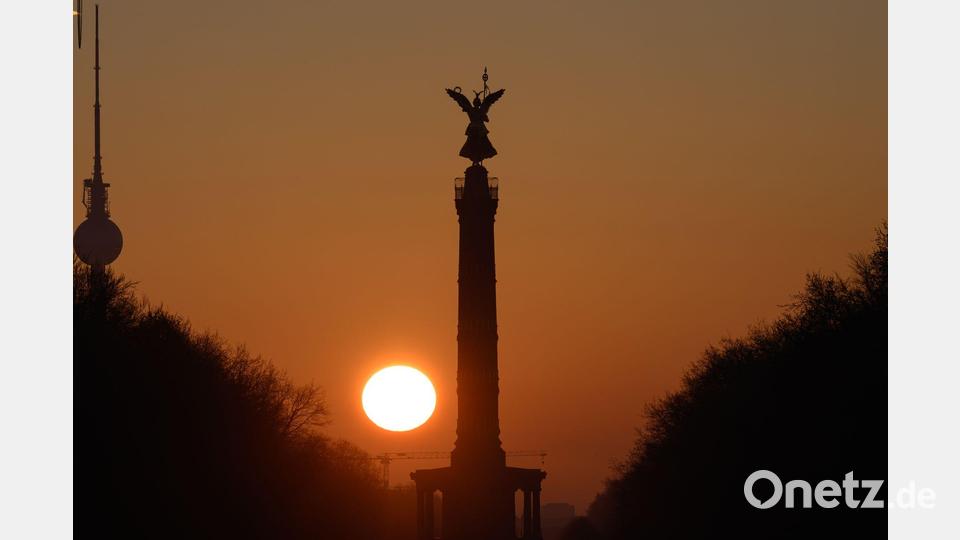 Die Sonne geht am Morgen bei wolkenlosem Himmel hinter der Siegessäule in Berlin auf. Bild: Soeren Stache/dpa