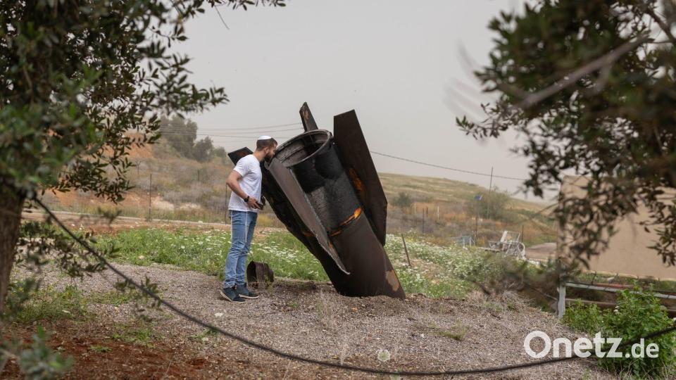 Ein israelischer Mann betrachtet in der jüdischen Siedlung im nördlichen Jordantal das Heckteil einer vom Iran abgeschossenen ballistischen Rakete. Bild: Oren Ziv/dpa