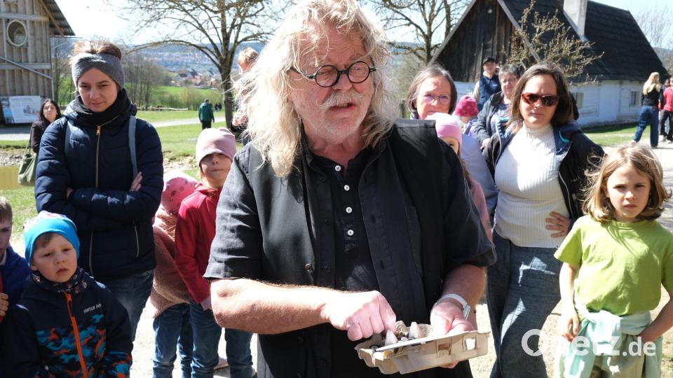 Museumspädagoge Walter Bauer stellt den Kindern Fragen rund um das österliche Brauchtum und verteilte Knöpfe zum Knipsen. Bild: Hirsch