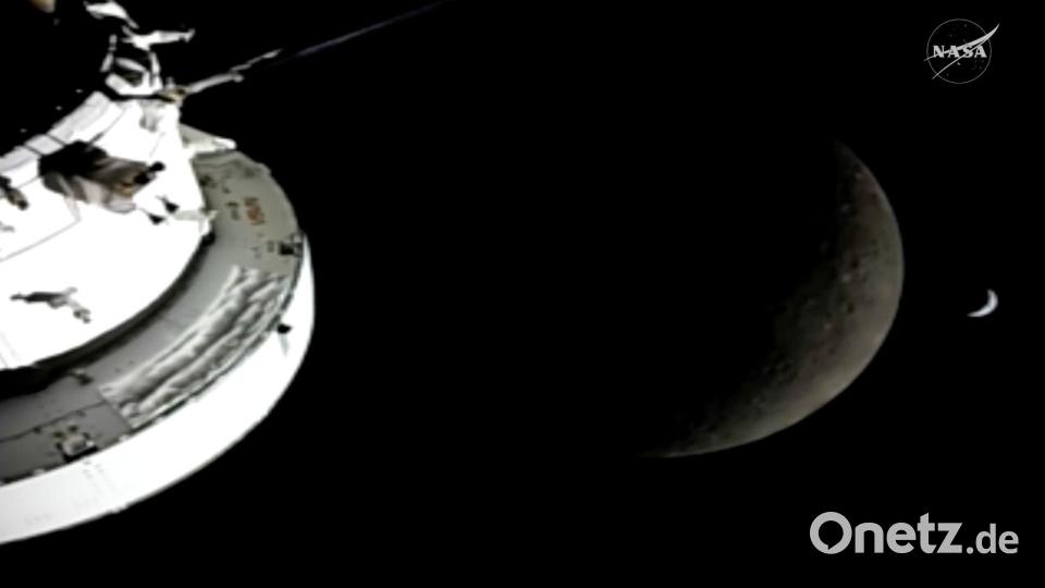 In diesem Bild aus einem von der NASA zur Verfügung gestellten Video sind die „Orion“-Raumkapsel, der Mond und die Erde (r) von einer Kamera aus zu sehen, während die „Artemis 2“-Besatzung und das Raumschiff weiter in den Weltraum vordringen. Bild: Uncredited/NASA/dpa