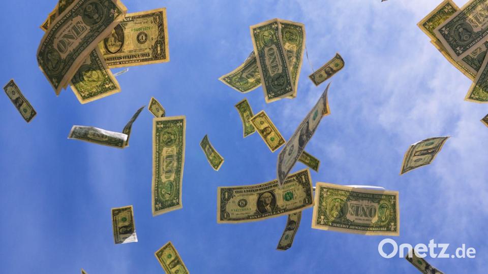 Ein-Dollar-Scheine aus den USA fallen mit dem Himmel im Hintegrund in Dallas. Bild: LM Otero/AP/dpa