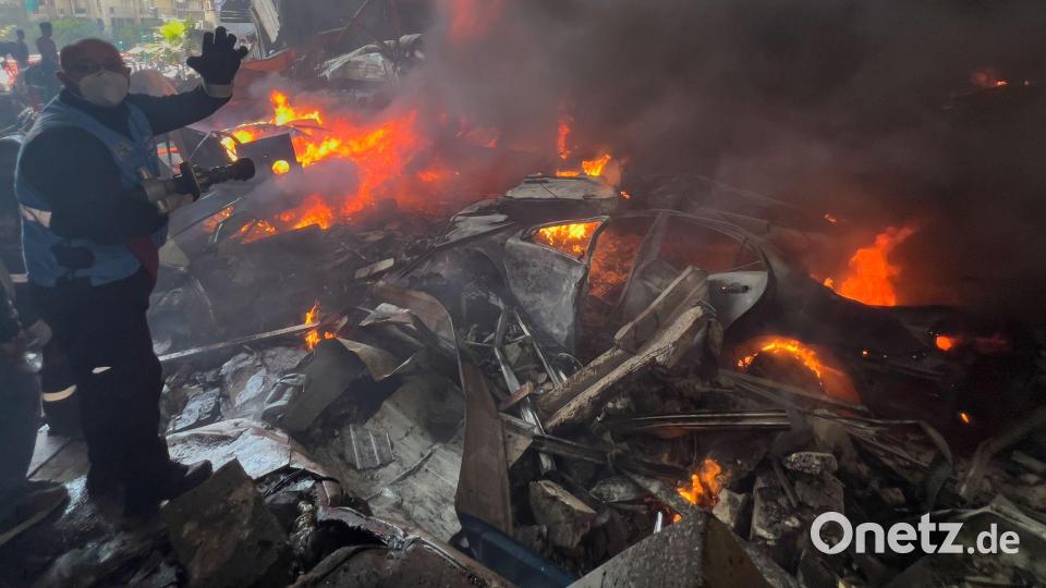 Ein Rettungsarbeiter löscht brennende Autos am Ort eines israelischen Luftangriffs im Zentrum von Beirut. Bild: Hussein Malla/AP/dpa