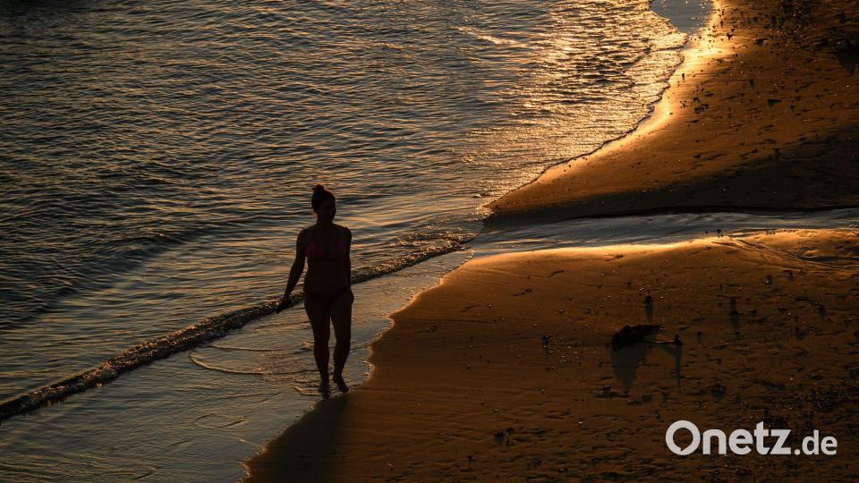 Spaziergang in der Abendsonne: Eine Person geht über den Sand am Milk Beach. Bild: George Chan/AAP/dpa
