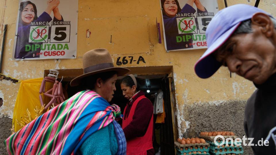Fußgänger gehen an Wahlkampfplakaten in Cuzco in Peru vor den Präsidentschaftswahlen am Wochenende vorbei. Bild: Martin Mejia/AP/dpa