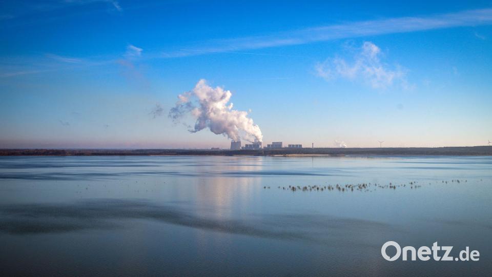 Rauchschwaden vor blauem Himmel: Das Kraftwerk Jänschwalde ist hinter dem Cottbuser Ostsee zu sehen. Bild: Soeren Stache/dpa