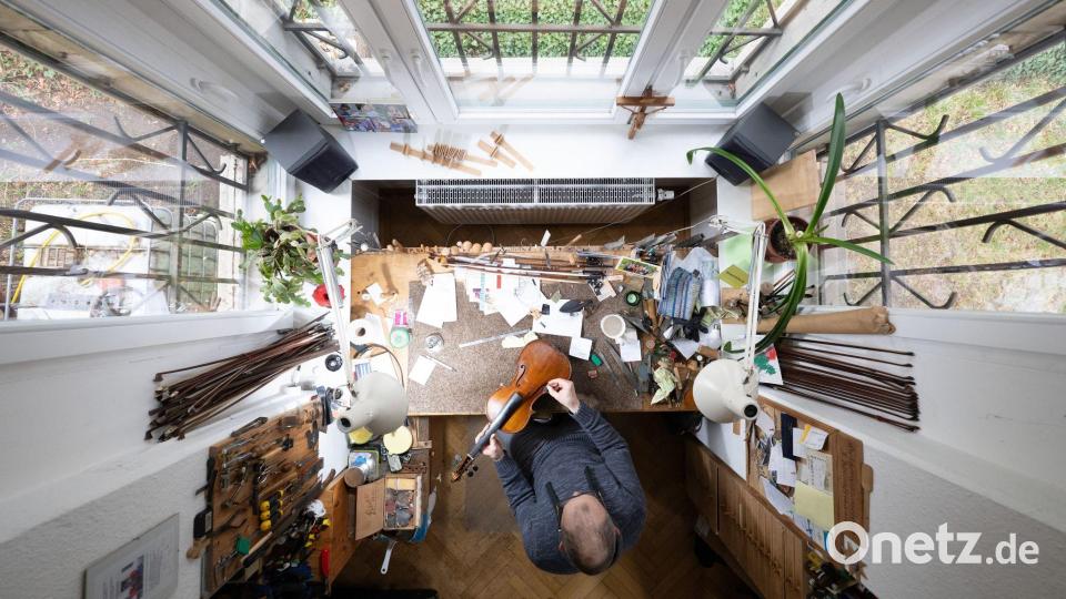 Kunsthandwerk von oben: Ein Geigenbauer arbeitet in einer Geigenwerkstatt an einer Bratsche. Bild: Sebastian Kahnert/dpa