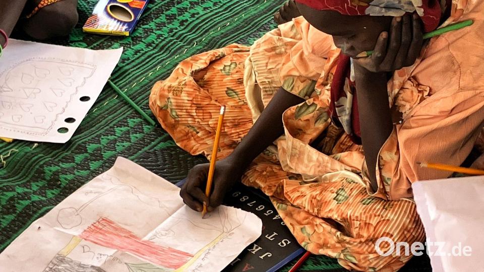 Ein kleines Mädchen malt die sudanesische Flagge. Bild: Eva Krafczyk/dpa