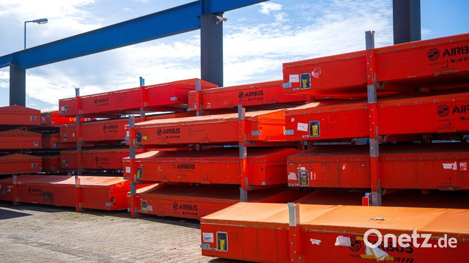 Vor der Werkhalle warten beschädigte Fahrzeugteile auf die Reparatur. Bild: Sina Schuldt/dpa