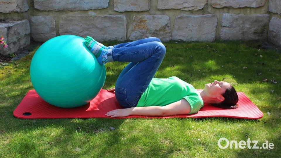 Bei dieser Übung liegen die Fersen auf dem Gymnastikball, die Beine sind zunächst gestreckt. Dann die Knie zum Bauch ziehen, die Fersten bleiben auf dem Ball liegen. Anschließend Beine wieder strecken. Das Ganze 10 bis 15 Mal wiederholen. Bild: Evi Wagner