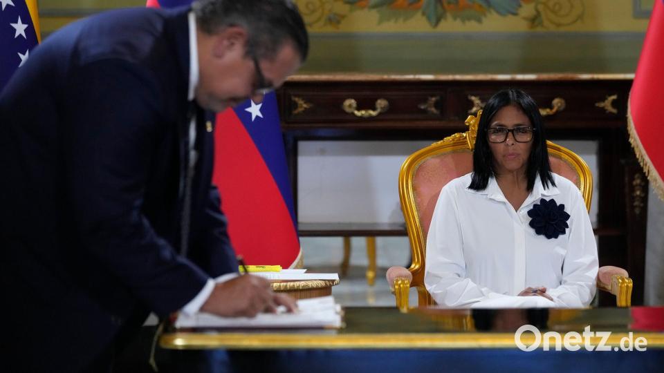 Der Chevron-Vertreter Mariano Vela unterzeichnet ein Abkommen. Bild: Ariana Cubillos/AP/dpa