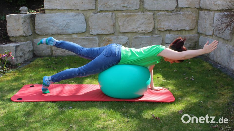 Mit dem Bauch auf den Ball legen. Mit den Händen vor dem Ball abstützen, Füße auf dem Boden abstellen. Bauch- und Gesäßmuskeln anspannen, linken Arm und rechtes Bein anheben und strecken. Rund 15 Sekunden halten, dann Arm und Bein wechseln. Die Übung drei- bis fünfmal wiederholen. Bild: Evi Wagner